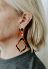 Timeless statement dangle earrings featuring a classic tortoise design with fun pops of red beads