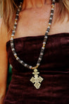 Neutral long handmade necklace featuring a coptic cross pendant