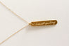 Minimalist, hand-assembled necklace with a gold-plated script charm on an 18k gold filled chain