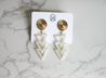 Lightweight, edgy arrow earrings for women made out of resin with a spiral detail gold topper handmade by artisans in Charlotte, NC, USA.