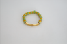 Add a splash of spring to your look with the spirited Shekeba Vibrant Bracelet. This golden charm features a mix of green and yellow accents that add a playful pop of color - all hand-assembled with purpose!