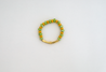 Add a splash of spring to your look with the spirited Shekeba Vibrant Bracelet. This golden charm features a mix of green and yellow accents that add a playful pop of color - all hand-assembled with purpose!