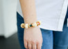 Channel your inner strength with the Sheila Agate Bracelet. Made with recycled paper beads of ivory, brass, green, and berry tones, this chunky bracelet features a powerful agate gemstone known to give courage and strength. Perfect for adding a touch of uniqueness and positivity to any outfit.