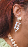 Woman wearing lightweight, edgy arrow earrings for women made out of resin with a spiral detail gold topper handmade by artisans in Charlotte, NC, USA.