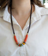 Woman wearing handmade colorful clay bead with leather cord necklace