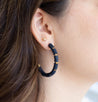 Woman wearing handmade navy blue with gold bead hoop earrings 