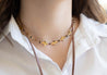 woman wearing dainty gold flower necklace with black seed beads