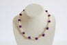 Necklace with purple and light pink beads on a mannequin bust against a white background.