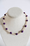 Necklace with purple and light pink beads on a gray bust
