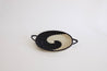 Round woven tray with black and beige pattern.