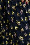 Wrap skirt with black background with neon yellow and purple small repeating floral clusters