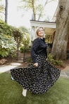 Wrap skirt with black background with neon yellow and purple small repeating floral clusters