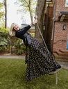 Wrap skirt with black background with neon yellow and purple small repeating floral clusters