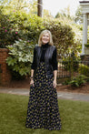 Wrap skirt with black background with neon yellow and purple small repeating floral clusters
