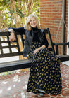 Wrap skirt with black background with neon yellow and purple small repeating floral clusters