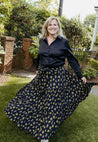 Wrap skirt with black background with neon yellow and purple small repeating floral clusters