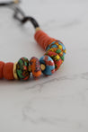 Close up of handmade colorful clay bead with leather cord necklace