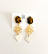Handmade dangle earrings with a tortoise shell topper, gold-plated sun middle charm, and diamond-shaped cattle horn charm at the end