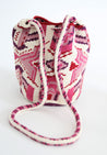 Pink, purple, and white hand-crocheted bucket bag with pom poms