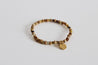 Earthy minimalist bracelet with natural stone beads and gold charm.