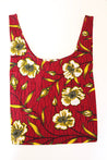 Red floral tote bag with yellow and white flower print and leaves on a deep red background.