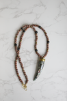 A bold and long statement necklace for women featuring an unique, Abalone gem claw pendant handmade by artisans in Charlotte, NC, USA.