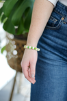 Add a pop of color to your wardrobe with the Leeda Flower Bracelet. This playful piece features a mix of metal, glass, and agate gemstones in shades of green, yellow, and white, reminiscent of a spring meadow
