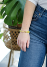 Add a splash of spring to your look with the spirited Shekeba Vibrant Bracelet. This golden charm features a mix of green and yellow accents that add a playful pop of color - all hand-assembled with purpose!