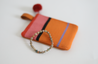 Simple bracelet with orange coin purse.