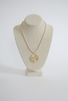 white and light pink beaded necklace with a gold tree charm.