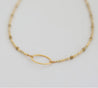 Handmade, minimalist, and short gold beaded necklace with gold-plated oval pendant in center