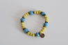 Lightweight beaded bracelet handmade with recycled paper beads in yellow and blue.
