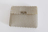 Sustainable recycled plastic clutch in the colors white and sand.