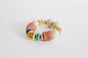 beaded, wooden bracelet in blush, cream, yellow, and colorful beads