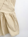 Textured 100% cotton, cream-colored wrap skirt with one tier at the bottom sewn in the USA