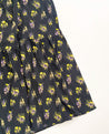 Wrap skirt with black background with neon yellow and purple small repeating floral clusters