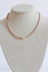 beaded necklace in blush pink with a white, clear bead in the middle