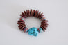reddish beads with colorful beads bracelet with a turquoise stone.