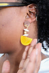 Unique handcrafted earrings with yellow, white, and gold elements.