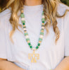 beaded long necklace in shades of green, with a thunder bird pendant.